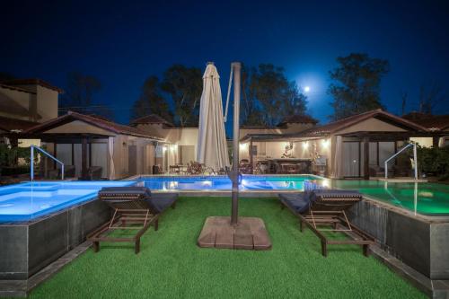 ein Schwimmbecken mit zwei Stühlen und einem Sonnenschirm in der Unterkunft Emmalu Hotel Boutique in San Marcos
