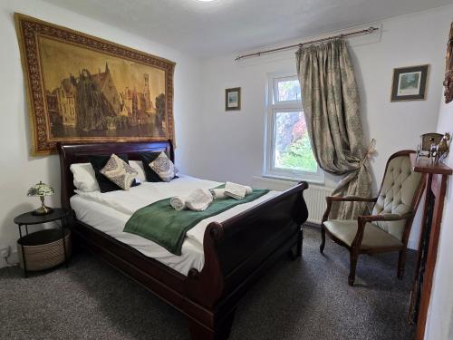 a bedroom with a large bed and a window at Cute Cottage in Egham Heathrow- 7 Guests 3 bedrooms in Egham