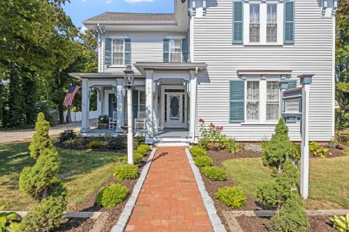 a white house with a blue door and a brick walkway at Isaiah Jones Homestead Bed and Breakfast in Sandwich