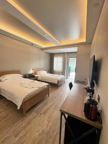 a hotel room with two beds and a desk and a television at Yerevan Street hotel in Yerevan