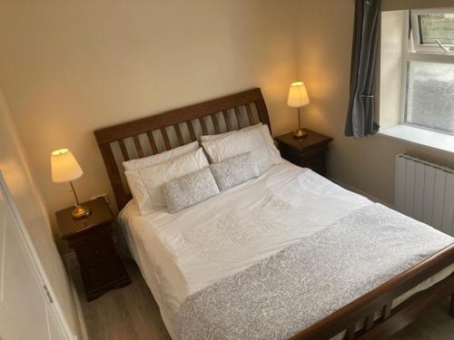 a bedroom with a large bed with two lamps on tables at MeadowView Apt B -2 mins walk Carrigaline town -sleeps 4 - 2 Adults and 2 Kids in Carrigaline