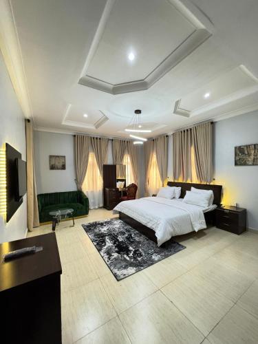 a large bedroom with a bed and a couch at Klue Homes in Maiyegun