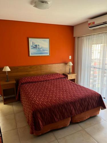 a bedroom with a large red bed with orange walls at Maison Apart Hotel in Mar del Plata