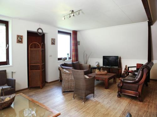 a living room with leather furniture and a tv at Farmhouse home in Eede in Eede