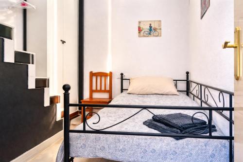 a small bedroom with a bed and a chair at CASA ADELA - Playa 2 min - Aire Acondicionado - WIFI - Parking cercano in Barbate