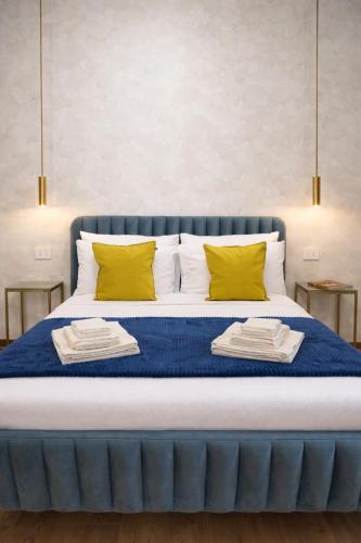 a blue bed with two yellow pillows on it at ClaMar Apart Hotel in Porto Ercole