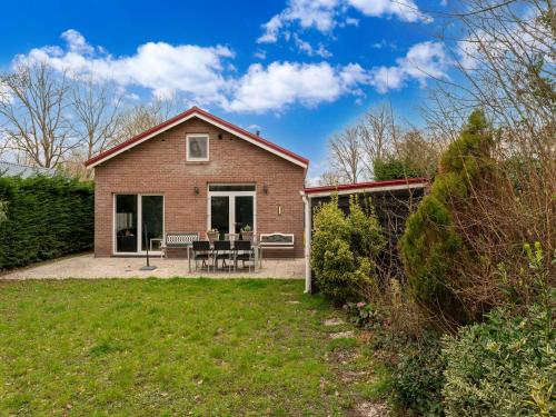 a house with a patio and a yard at Holiday Home in Zeeland near Lake in Baarland