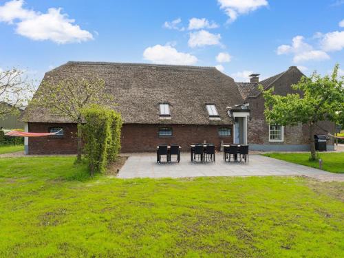 a house with tables and chairs and a frisbee at Farmhouse with terrace in Montfoort in Montfoort