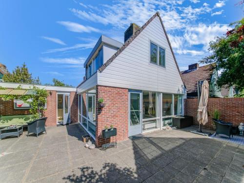 a home with a patio and a house at Comfortable vacation home near the sea in Noordwijkerhout