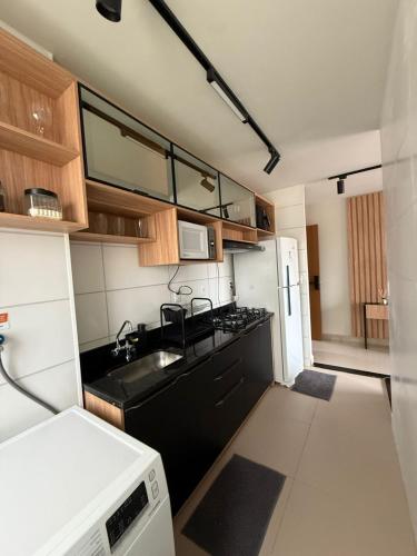 a small kitchen with a sink and a microwave at 098house havana in São Luís
