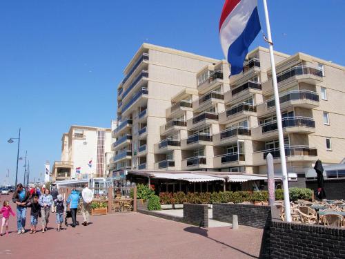 people walking in front of a building with a flag at Apartment in Noordwijk near Beach in Noordwijk