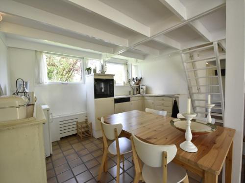 a kitchen with a wooden table and chairs in a room at Holiday Home Warmenhuizen near Dunes in Warmenhuizen