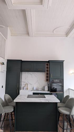 a kitchen with green cabinets and a counter with chairs at Historic Dover Stay with Stunning Castle View in Dover