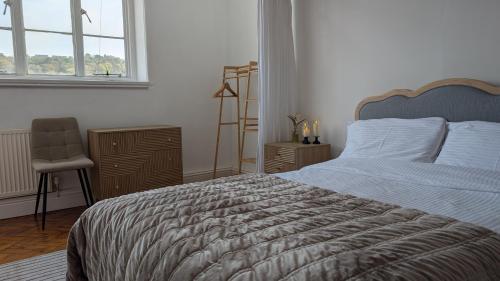 a bedroom with a bed and a chair and a window at Historic Dover Stay with Stunning Castle View in Dover
