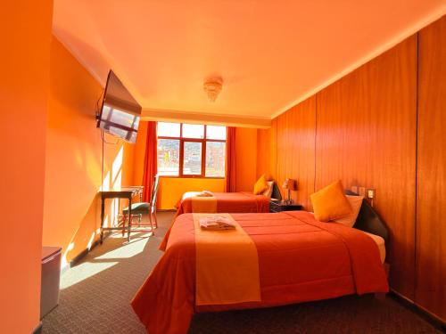a hotel room with two beds and a window at Hostel Sillustani Inn Puno - Con Cochera in Puno