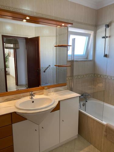 a bathroom with a sink and a mirror and a tub at Esteves Apartment - Alvor Center in Alvor