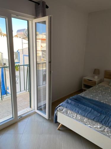 a bedroom with a bed and a sliding glass door at Esteves Apartment - Alvor Center in Alvor
