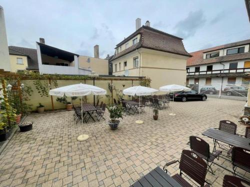 a patio with umbrellas and tables and chairs at Wohngemeinschaft mit Privatzimmern in Niederdorla