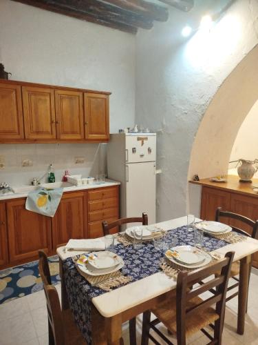 a kitchen with a table with chairs and a white refrigerator at Almyra traditional residence in Andros