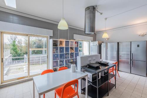 a kitchen with a table and some orange chairs at HI Porto - Pousada de Juventude in Porto