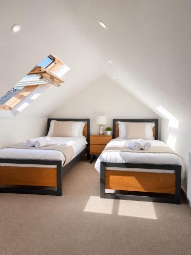 two beds in a room with a attic at The Hillcrest, Luxury Accommodation in Castleblayney Town in Castleblayney