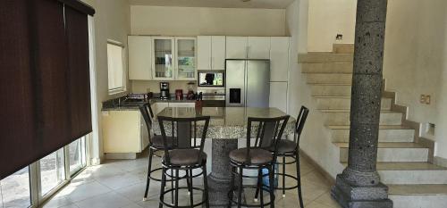 a kitchen with a table with chairs and a counter at Casa Velero in Puerto Vallarta