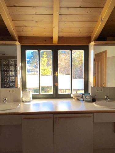 a kitchen with two sinks and two windows at Petra Maria Sölle - Ferienhaus sehr privat in Presseggersee