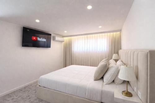a bedroom with a bed with a television on the wall at Private Douro- Quinta das Susandas in Mesão Frio