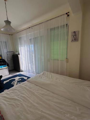 a bedroom with a white bed and a window at Paradise Coast House in Orfánion