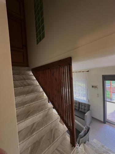 a staircase in a living room with a couch at Paradise Coast House in Orfánion