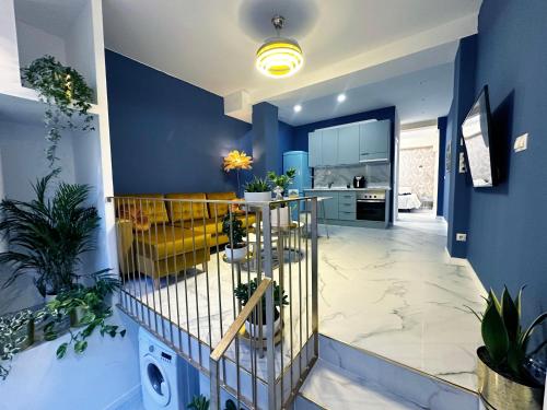 a living room with a blue wall and a table with plants at Chinatown Luxury Apartment in Madrid