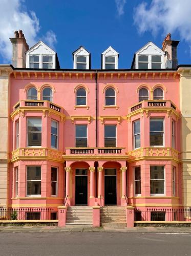 a pink building on the side of a street at Burlington Palace Eastbourne Seafront Villa with Garden. in Eastbourne