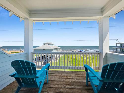 two blue chairs on a porch with a view of the ocean at Blue Anchor home in Crystal Beach