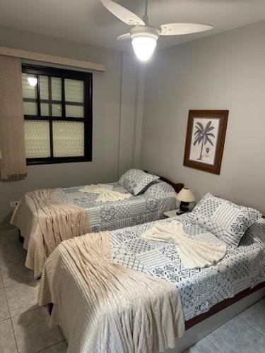 a bedroom with two beds and a window at Apto a 3 quadras do centro, 2 quartos lazer comp in Serra Negra
