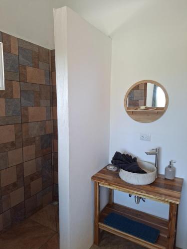 a bathroom with a sink and a mirror on a table at Pura Vista Lodge in Sámara