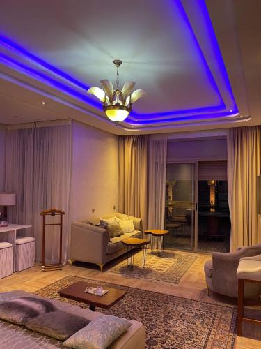 a living room with a couch and a blue ceiling at Dar Ghita in Arrouaïs