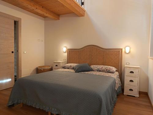 a bedroom with a large bed and a wooden headboard at casa del corso 27 in Sirolo