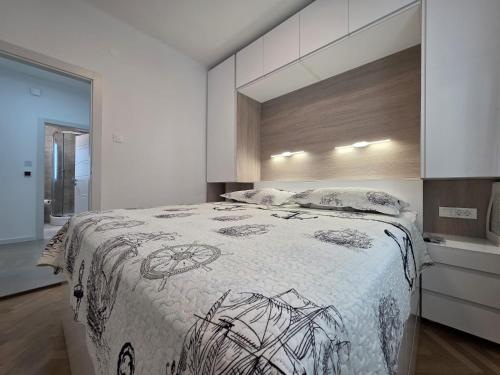 a bedroom with a bed with a black and white blanket at AiZ in Kastel Stafilic