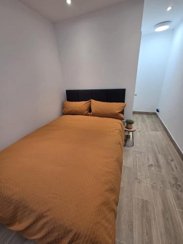 a large bed in a room with a wooden floor at Holyport Studio flat in Bray