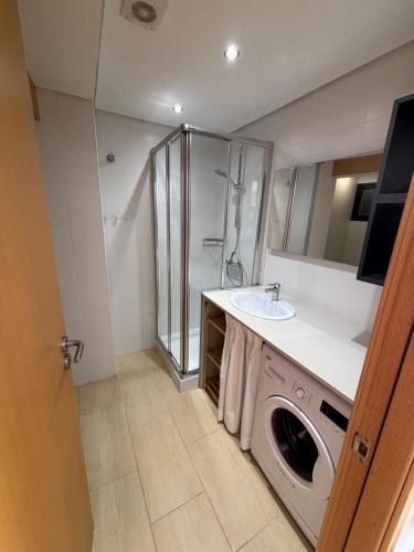 a bathroom with a sink and a washing machine at Apartamentos QEli in Son Carrio