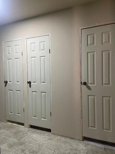 two white doors in a room with a wall at Yek Hostels in Santa Ana