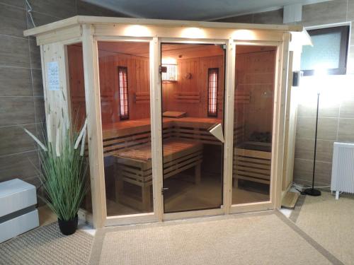a large wooden enclosure with a plant in a room at Siggis und Anyas Ferienwohnung mit Sauna und XXXL-Dusche in Sasbachwalden