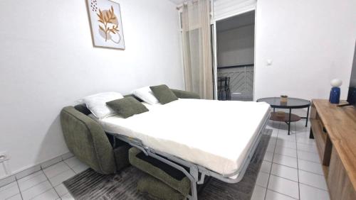 a bed in a room with a couch and a table at L'Échappée Bleue Sea view studio in Moule in Le Moule