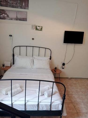 a bedroom with a bed and a tv on the wall at Studio Panagiota in Kavála