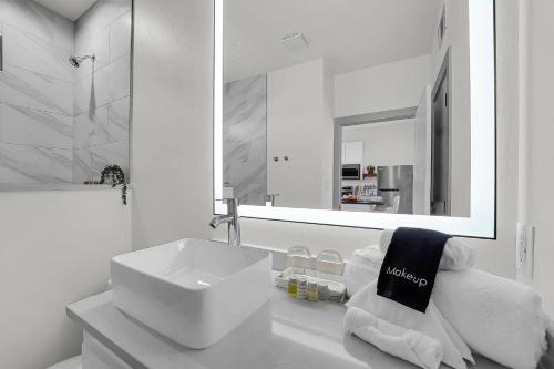a white bathroom with a sink and a mirror at Medicine Park Flat's #05 in Medicine Park