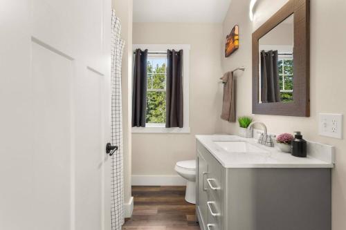 a bathroom with a sink and a toilet and a mirror at The Overlook at Orchard Hills in Bernard