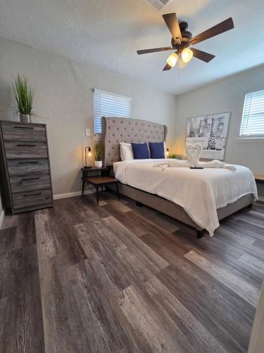 a bedroom with a large bed and a ceiling fan at Brand new everything! Adjustable beds! Best House in Lawton