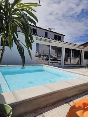 a swimming pool in front of a house at Mosteiros Vineyards House, Nature Praia&Sunset in Mosteiros