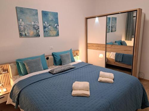 a bedroom with a blue bed with two towels on it at Dorea in Jagodje