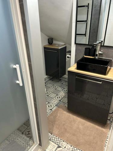 a bathroom with a black sink and a sink at Le studio de Louisette in Châteaudun